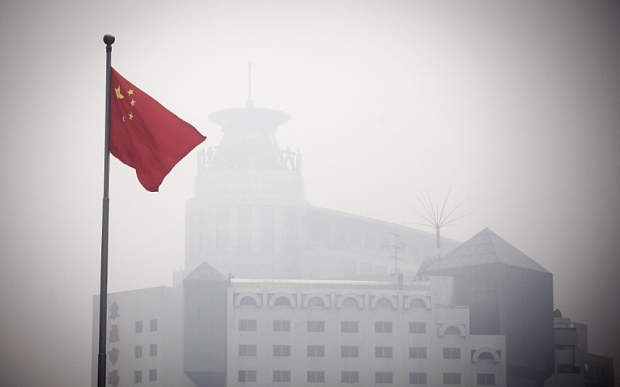 China smog...epa03022451 The Chinese national flag flames in front of a building barely visible due to heavy smog in Beijing, China, 02 December 2011. As the Climate Change Summit aimed at cutting global carbon emissions is held in Durban, South Africa, environmental officials in China, currently the world's largest emitter of greenhouse gases, agree that the the country's air standards are too weak. Meanwhile, Chinese environmental officials have ordered fines on eight power plants accused of violating pollution limits and falsifying data. EPA/DIEGO AZUBEL