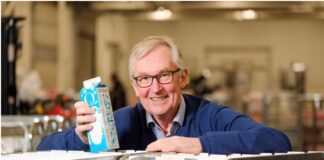 Q-sjef Bent Myrdahl med melkekartongen som skal spre gode historier fra innovative virksomheter.